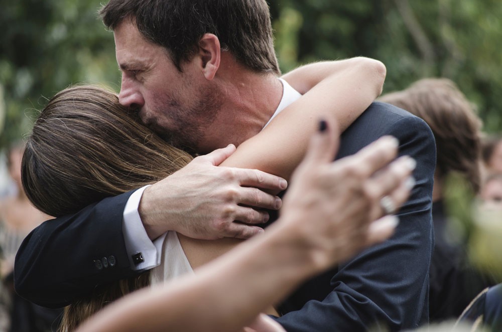 padre dándole un beso y un abrazo a su hija